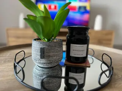 a table with a jar and a potted plant on it at Spacious 2 bedroom, 2 bathroom unit in Pretoria