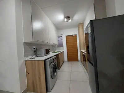a kitchen with a refrigerator and a washer and dryer at Spacious 2 bedroom, 2 bathroom unit in Pretoria