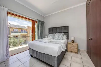 a bedroom with a large bed and a large window at Carlswald Escape in Midrand