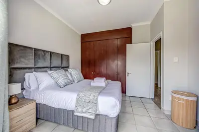 a bedroom with a large bed with a wooden headboard at Carlswald Escape in Midrand