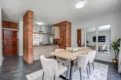 a kitchen and dining room with a wooden table and chairs at Carlswald Escape in Midrand