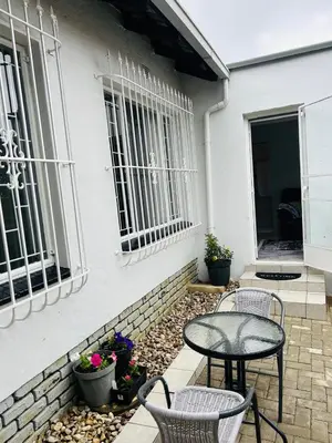 a patio with a table and chairs in front of a house at Rugare Haven in Kempton Park
