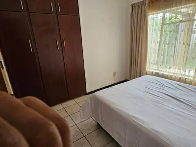 a bedroom with a white bed and a window at The comfort in Polokwane