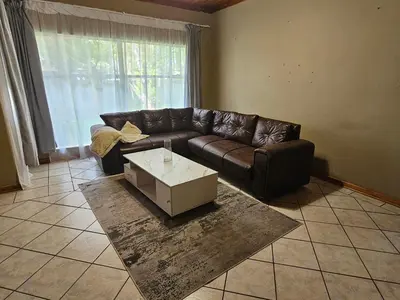 a living room with a leather couch and a coffee table at The comfort in Polokwane