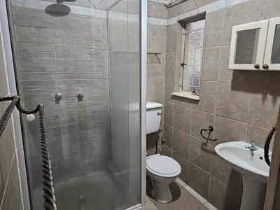 a bathroom with a shower and a toilet and a sink at The comfort in Polokwane