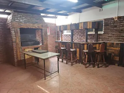 a room with a table and chairs and a brick wall at The comfort in Polokwane
