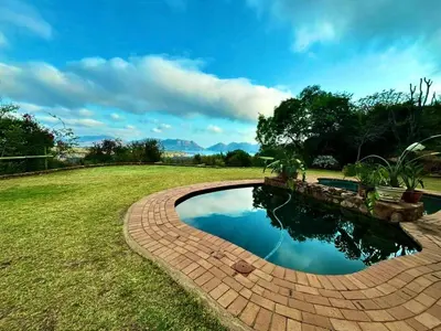 a brick walkway around a pool in a yard at Anahata Nature Resort in Hartbeespoort