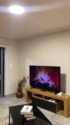 a living room with a large flat screen tv at Unmatched Stays in Kempton Park