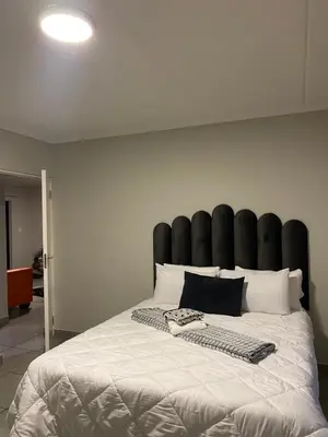 a large bed with a black padded headboard in a room at Unmatched Stays in Kempton Park