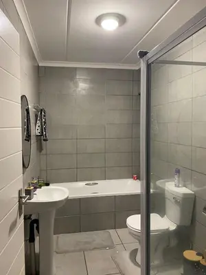 a bathroom with a sink and a toilet and a tub at Unmatched Stays in Kempton Park