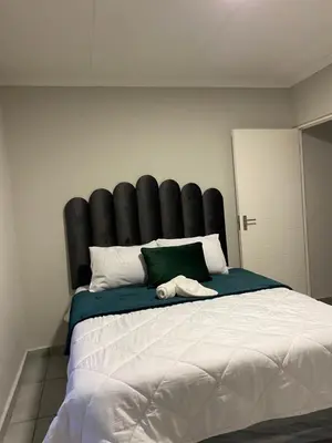 a large bed with a black headboard in a bedroom at Unmatched Stays in Kempton Park