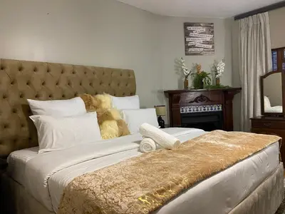 a bedroom with a large bed with a large headboard at Kloofyard Guesthouse in Pretoria