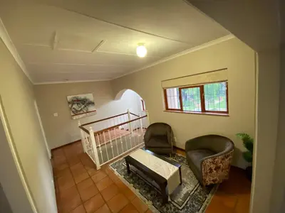 a living room with two chairs and a crib at Kloofyard Guesthouse in Pretoria