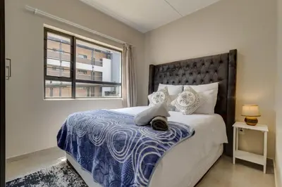a bedroom with a large bed and a window at Home Affairs by Waterfall in Midrand