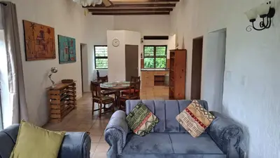 a living room with a blue couch and a table at Lakeview Lodge in Hazyview