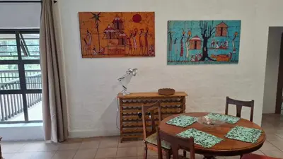 a dining room with a table and a table and a painting at Lakeview Lodge in Hazyview