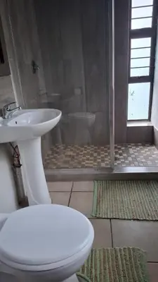 a bathroom with a toilet and a sink and a shower at Lakeview Lodge in Hazyview