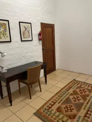 a room with a table and a chair and a door at Lakeview Lodge in Hazyview