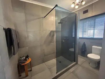 a bathroom with a glass shower with a toilet at Warthog Wallow - Kruger National Park Phalaborwa in Phalaborwa