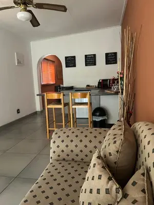 a living room with a couch and a kitchen at Warthog Wallow - Kruger National Park Phalaborwa in Phalaborwa