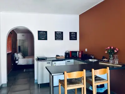 a kitchen with a table and two chairs and a counter at Warthog Wallow - Kruger National Park Phalaborwa in Phalaborwa
