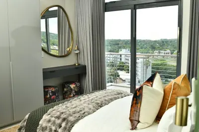 a bedroom with a bed and a large window at 438 The Capital Trilogy in Pretoria