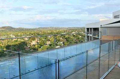 a glass balcony with a view of a city at 438 The Capital Trilogy in Pretoria