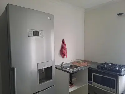 a small kitchen with a sink and a counter at Buccleuch Home in Sandton