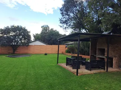 a gazebo with two benches in a yard at Buccleuch Home in Sandton