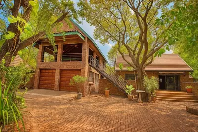 a house with a brick driveway in front of it at Tree Lodge by My Adventure House in Marloth Park