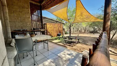 a porch of a house with a table and chairs at Figtree Escape in Marloth Park