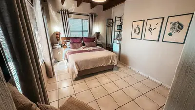 a bedroom with a bed and a tiled floor at Figtree Escape in Marloth Park