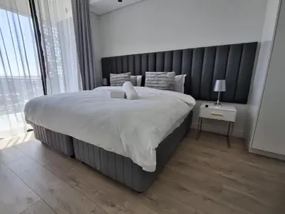 a bedroom with a large bed with a large window at Ellipse 1-Bedroom Lux Apartment in Midrand