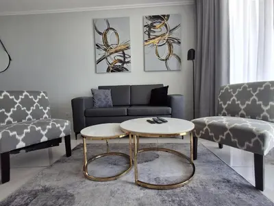 a living room with a couch and a table at Ellipse 1-Bedroom Lux Apartment in Midrand