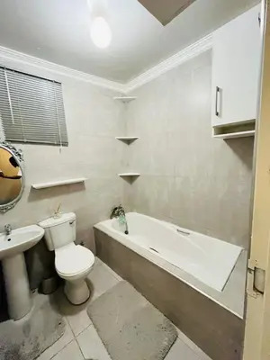 a bathroom with a toilet and a tub and a sink at Legae la rena in Polokwane