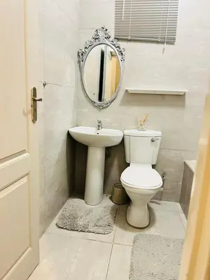a bathroom with a toilet and a sink and a mirror at Legae la rena in Polokwane