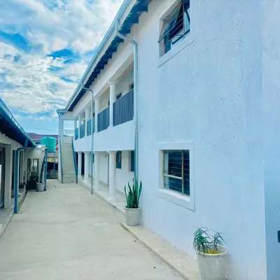 a white building with potted plants in front of it at Legae la rena in Polokwane
