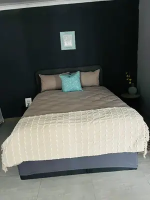 a bed in a bedroom with a black wall at Legae la rena in Polokwane