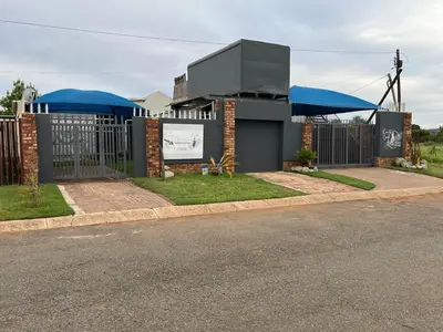a building with blue umbrellas on the side of a street at Kiewiets Nest Guesthouse in Pretoria
