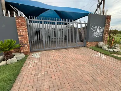 a gate with a blue canopy over a brick walkway at Kiewiets Nest Guesthouse in Pretoria
