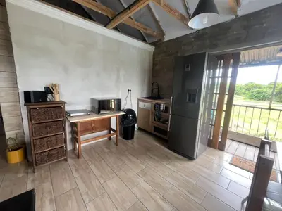a kitchen with a wooden table and a refrigerator at Kiewiets Nest Guesthouse in Pretoria