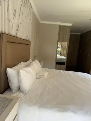 a bedroom with a large bed with white pillows at BEE Boutique Lodge in Nelspruit