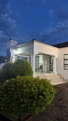 a white house with a porch and stairs on it at Makhuvha Tshilivho Luxury House in Thohoyandou