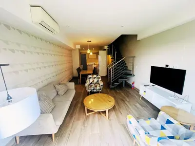 a living room with a couch and a tv at Regency Menlyn, 2 Bed Spacious Double Storey, New! in Pretoria