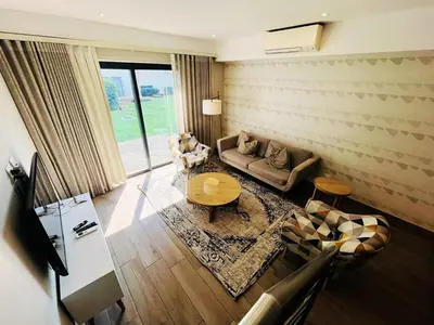 a living room with a couch and a table at Regency Menlyn, 2 Bed Spacious Double Storey, New! in Pretoria