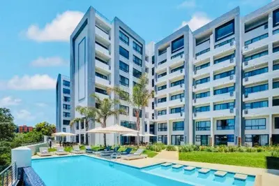 an apartment complex with a swimming pool and a building at Regency Menlyn Hotel 1Bed Apartment LongStay 32 percent off in Pretoria