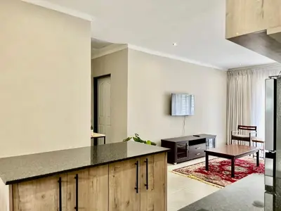 a kitchen with a table and a dining room at Midrand 2-Bedroom Oasis in Glen Austin in Midrand