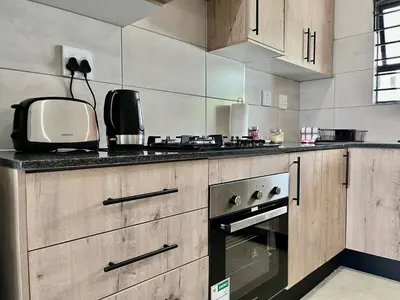 a kitchen with a stove and a microwave at Midrand 2-Bedroom Oasis in Glen Austin in Midrand