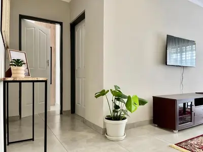 a living room with a potted plant and a tv at Midrand 2-Bedroom Oasis in Glen Austin in Midrand