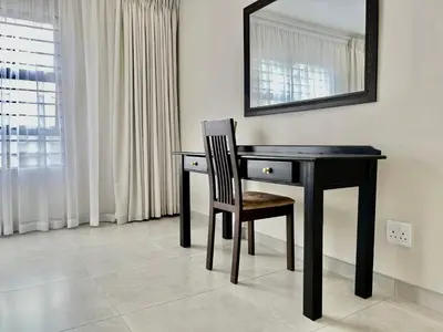a black desk with a chair and a mirror at Midrand 2-Bedroom Oasis in Glen Austin in Midrand
